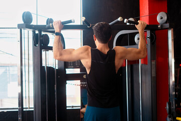 Man doing pull-ups on gym machine for strength training