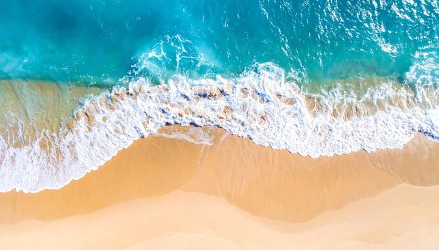 Aerial view waves crash onto a tan sandy beach, transitioning from clear turquoise to deeper blue ocean waters