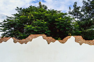 Decorative curved fence wall. Beautiful stuccoed brick wall features unique and attractive design, characterized by uneven, varying height levels. rendered brick wall design non uniform wall heights.