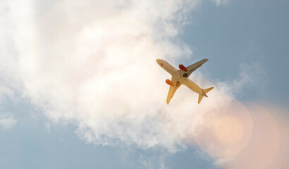Airplane flying above clouds on a clear day with blue sky