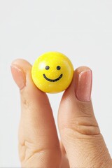 Small Yellow Smiley Face Ball Held By Hand