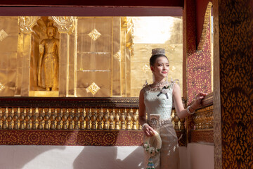 Beautiful young Asian woman in traditional Thai Dusit dress in an old temple in Chiang Mai,...