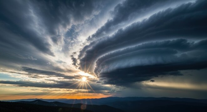 Dramatic sunset reveals swirling, layered clouds above a silhouetted mountain range - Powered by Adobe