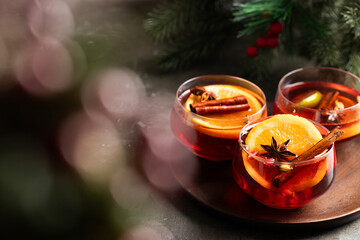 Festive drink with red wine, cinnamon, and orange, styled with seasonal greenery. A delicious symbol of Christmas cheer and cozy holiday evenings.