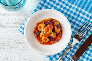 Cooked shrimp in rich tomato sauce served in white bowl