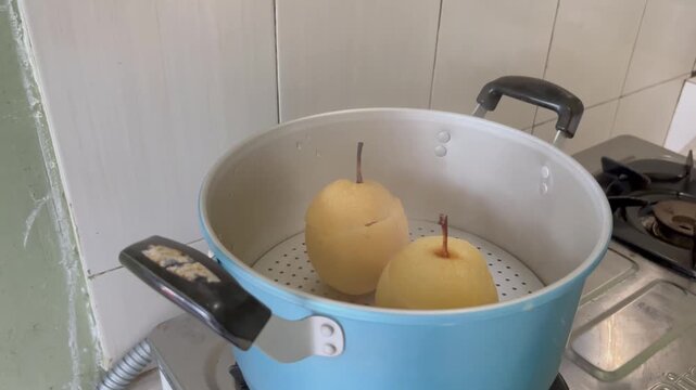 The process of making natural home cough medicine using pears and red ginger by steaming.