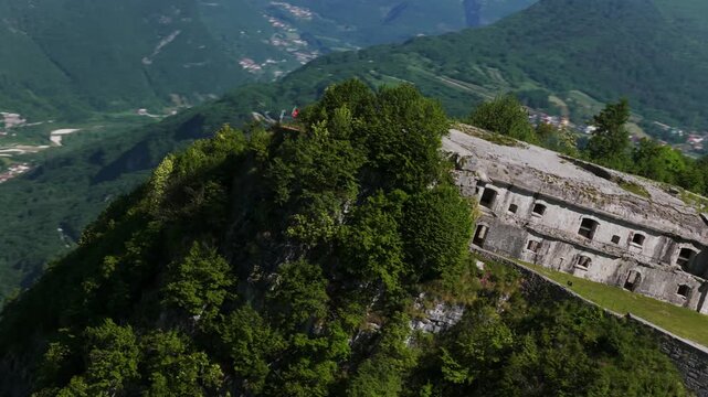 Aerial drone view of historic Forte Corbin, World War I fortress on mountain cliff overlooking green valley, military landmark for travel and history, Vicenza, Italy