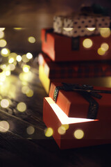 Gift boxes against a background bokeh of twinkling party lights. Luxury New Year gift. Christmas gift. Christmas background with gift box. Christmastime celebration