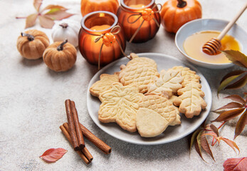 Autumn cookies, candles, pumpkins, honey, and cinnamon decorating table