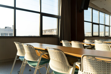 spacious conference room with rows of tables white chairs