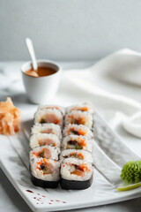 Freshly made sushi rolls with dipping sauce and garnishes