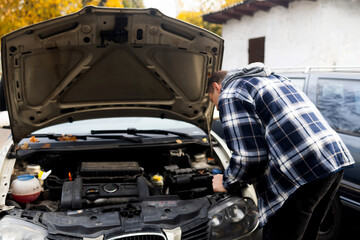 The man removed the car battery from the car in order to have it repaired or replaced. Transport service.