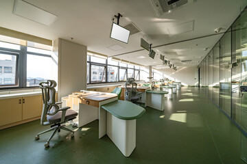 bright office in hospital with green furniture, large windows, and modern decor