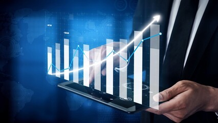 A professional businessman reviews financial growth data on a tablet, showcasing dynamic graphs and trends, symbolizing analytics and business success. Copula