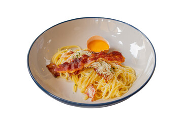 Delicious pasta carbonara served in a bowl, featuring a broken egg on top and crispy bacon