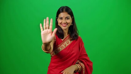 Warm Indian woman in saree greets you with a friendly wave on green screen, perfect for engaging content and diverse representation now