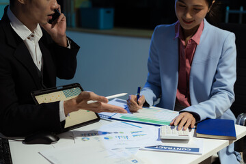 Financial analysts work overtime analyzing data on tablets, laptops, and graphs. Collaboration, teamwork, and planning.