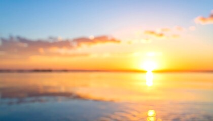 Blurred, sunlit seascape. Golden sunset reflects on the water's surface, fading into blue above