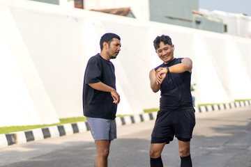 Asian Indonesian Men Checking Smartwatch After Running Exercise