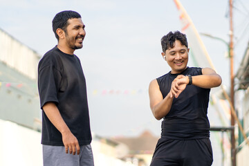 Asian Indonesian Men Checking Smartwatch After Running Exercise