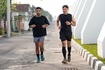 Asian Indonesian Men Running Together Outdoors for Exercise