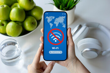 female hands holding phone with wi-fi banned on screen table
