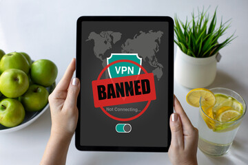 female hands holding computer tablet with VPN banned screen cafe