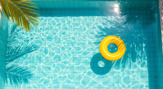 Refreshing swimming pool with crystal clear turquoise water and a yellow inflatable ring floating peacefully under the warm summer