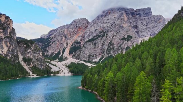 Lago di Braies or Lake Braies crystal blue lake with wooden rowing boats in Italian Dolomites. Mountain forest lake in Italian apls Dolomites South Tyrol. Mountain summit ridge. Glacier lake. 
