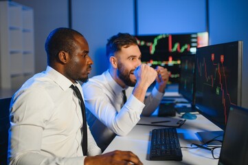 This is success. Two happy traders or financial analysts in the office celebrating a winning deal
