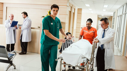 Healthcare team in a hospital corridor transports a patient on a stretcher while doctors consult...