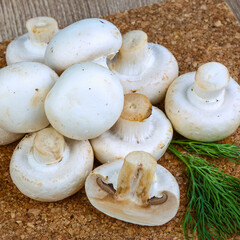Fresh white button mushrooms with dill on burlap background