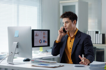 Naklejka premium Asian businessman discussing project details on smartphone
