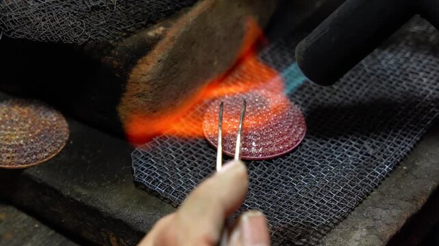 Close-up video showing a silversmith heating metal with a torch while crafting intricate jewelry in Celuk Village, Bali, Indonesia &mdash; famous for its traditional silver artistry and handmade crafts