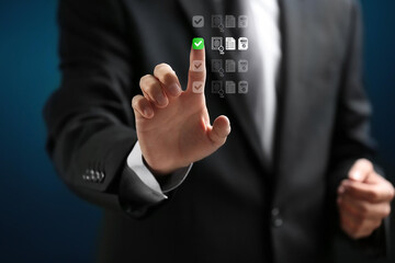 Businessman touching virtual checklist interface with green tick mark, representing task management, decision making, quality control, and digital approval process in modern business