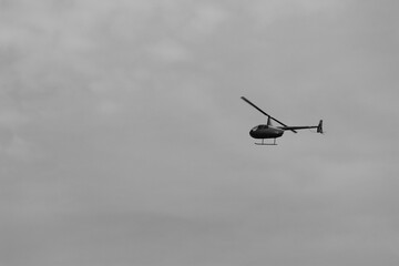 flying helicopter in grey sky © Rebecca