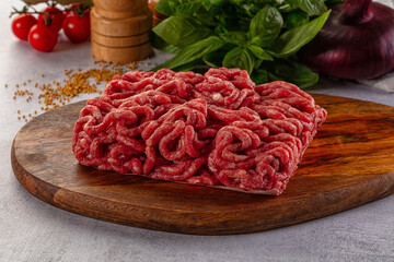 Raw minced beef meat over board