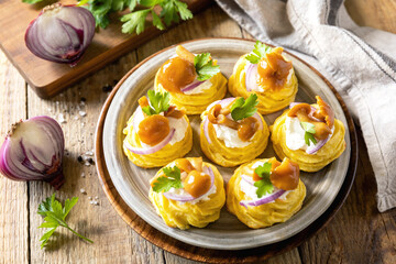 Potato tartlets filled with cottage cheese and marinated mushrooms on a rustic background.