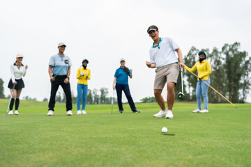 Group of young pro golfers swings their club on scenic golf course. 