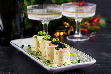 Canapes appetizer with salmon and black caviar on the Christmas table. Canapes with fish and caviar.