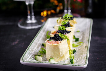 Canapes appetizer with salmon and black caviar on the Christmas table. Canapes with fish and caviar.