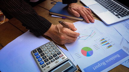 Busibessman hand reviewing a Business Report document and contract investment professional document agreement in the office