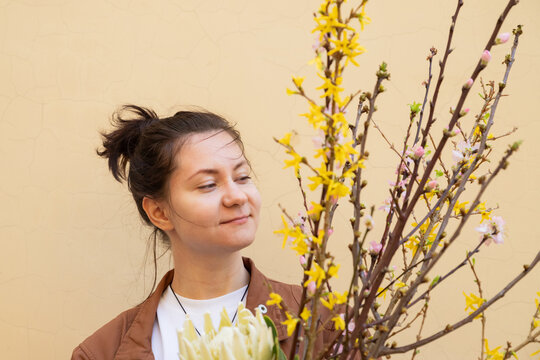 Portrait of a young woman florist with flowering branches, owner shop