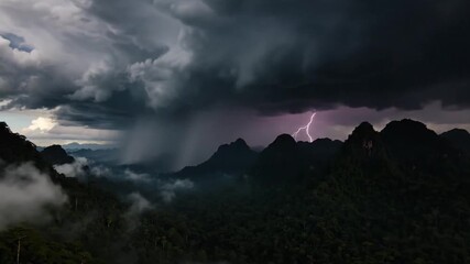 Dramatic thunderstorm over lush jungle mountain range with lightning strikes