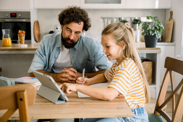 Father and child learning together using digital tablet at home