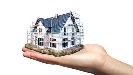 Hand holding a scale model of a single family house under construction