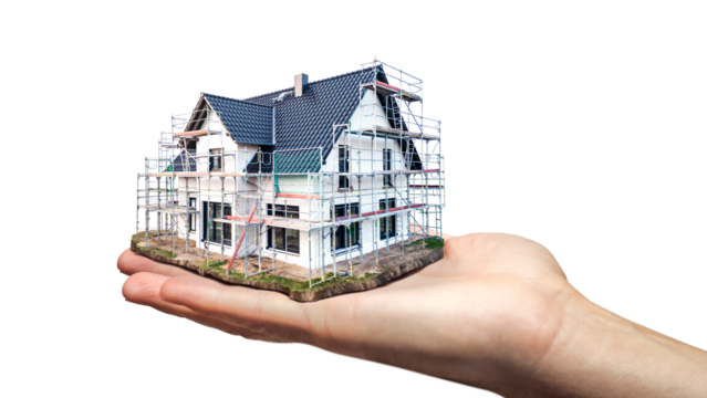 Hand holding a scale model of a single family house under construction