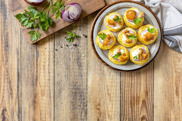 Potato tartlets filled with cottage cheese and marinated mushrooms on a rustic background. Top view.