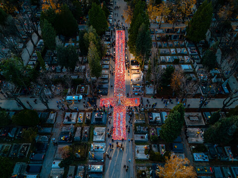 Aerial view of Mirogoj Cemetery's grounds ablaze with countless candles, creating a river of light amidst the solemn rows of tombstones, Zagreb, Zagreb, Croatia.