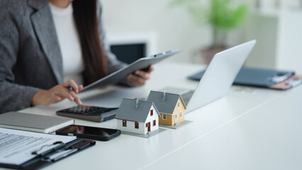 professional evaluates home loan and house contract and valuation at office desk